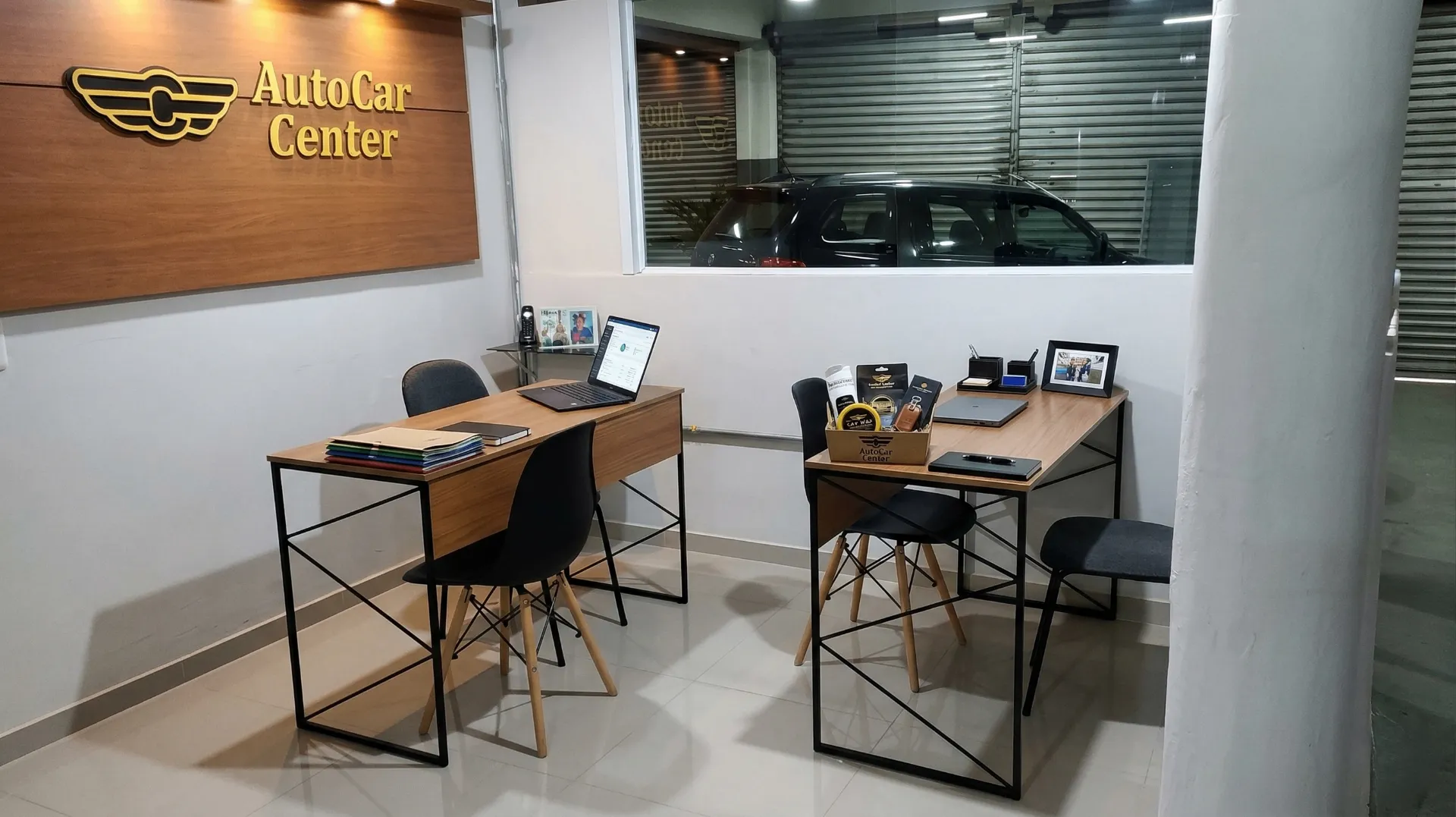 Recepção técnica da AutoCar Center com mesas de atendimento e veículo ao fundo.